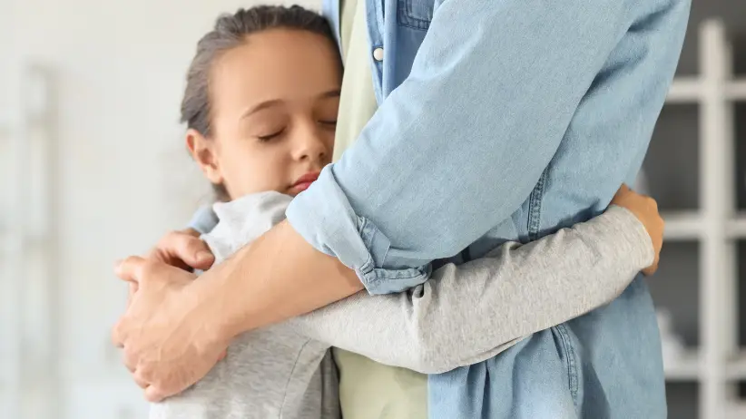 A child hugging their parent, symbolizing child custody and the best interests of the child standard in New York